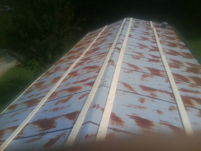Rusted metal roof panels with new wood purlins before replacement — Storm Damage Roof Repair in Husum by Roofing Brothers