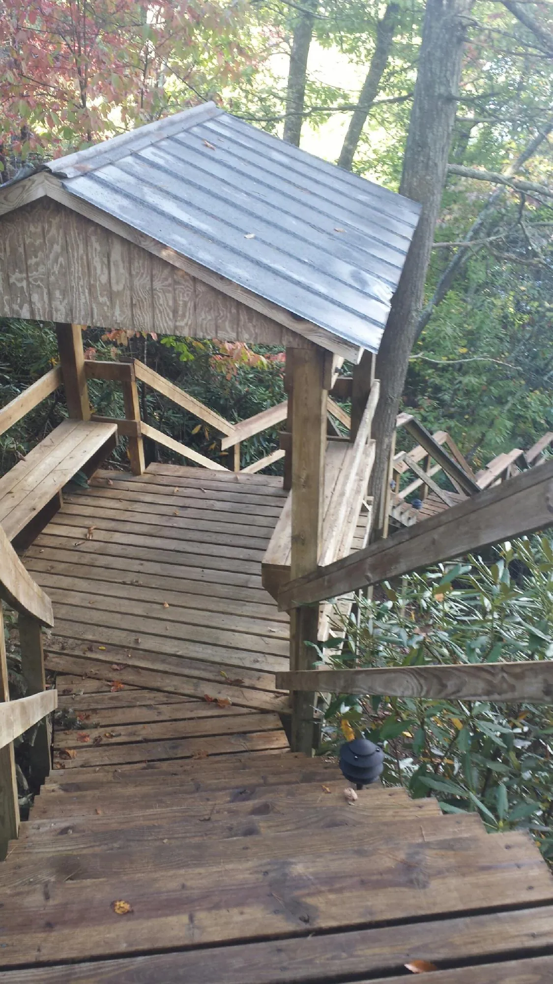Metal roofed shelter over wooden steps on a wooded walkway — Skylight Repair & Installation work by our crew in Husum
