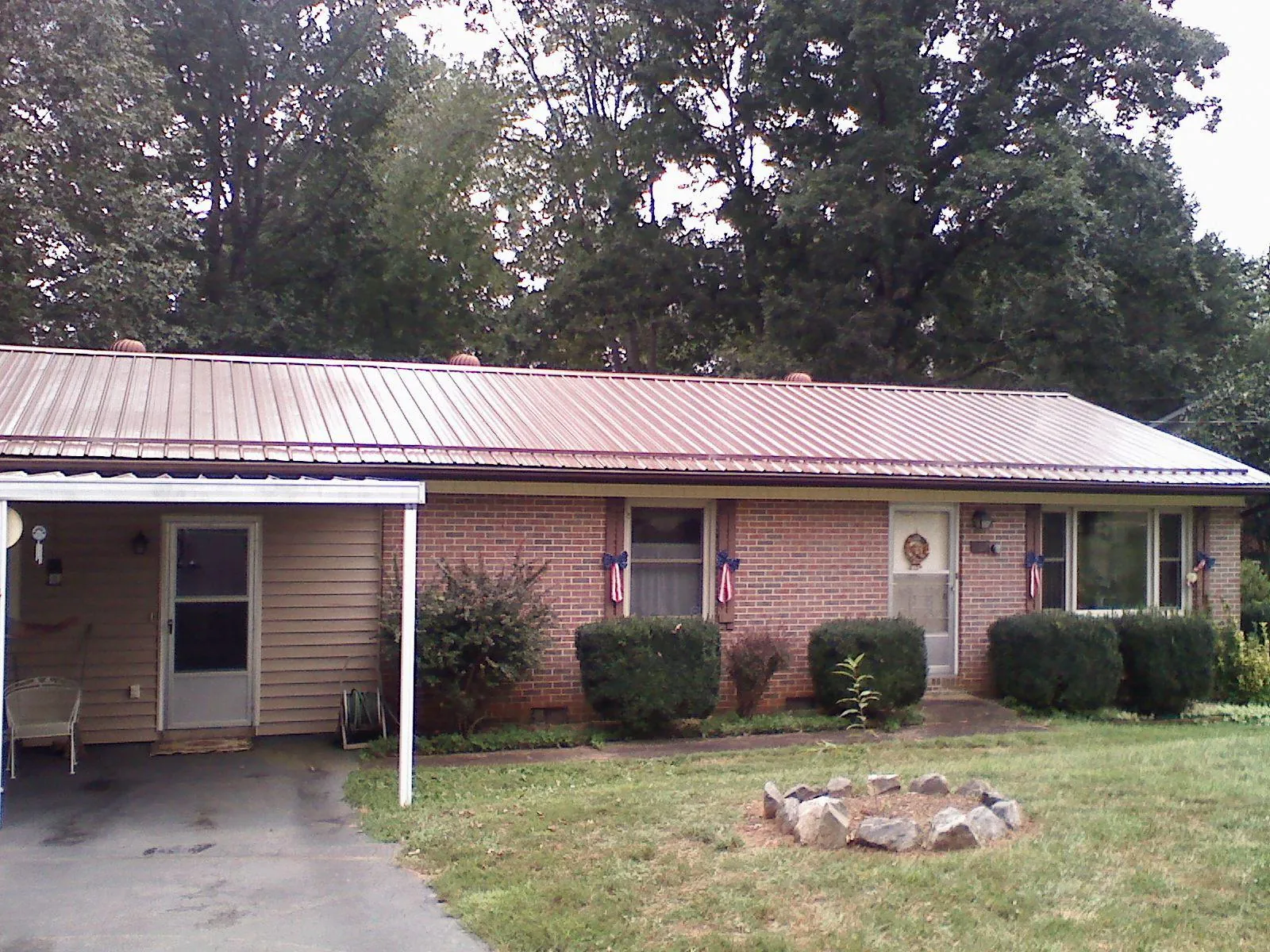 Bronze metal roof and carport on a brick ranch home — Roof Repair work by our crew in Husum